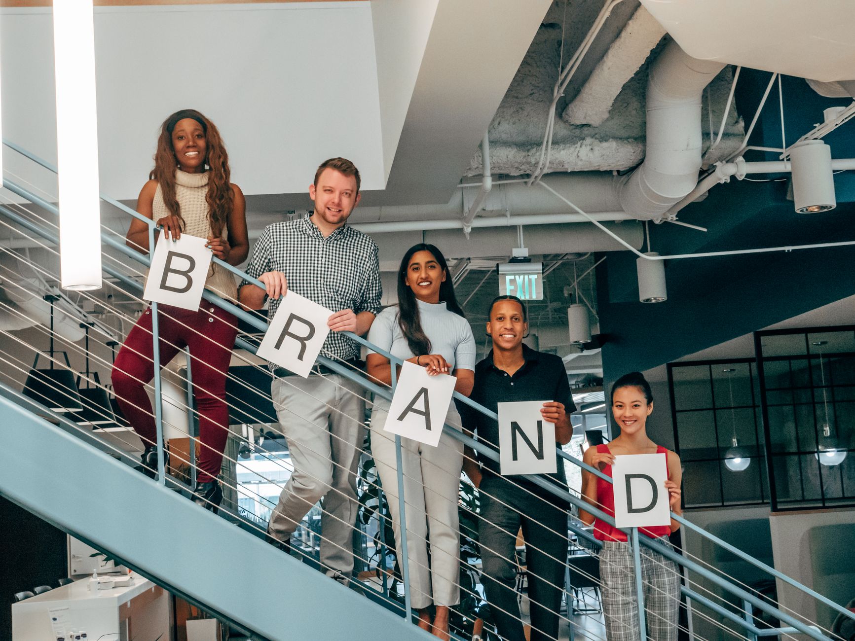 Diverse Group Of Adults Smiling And Holding Brand