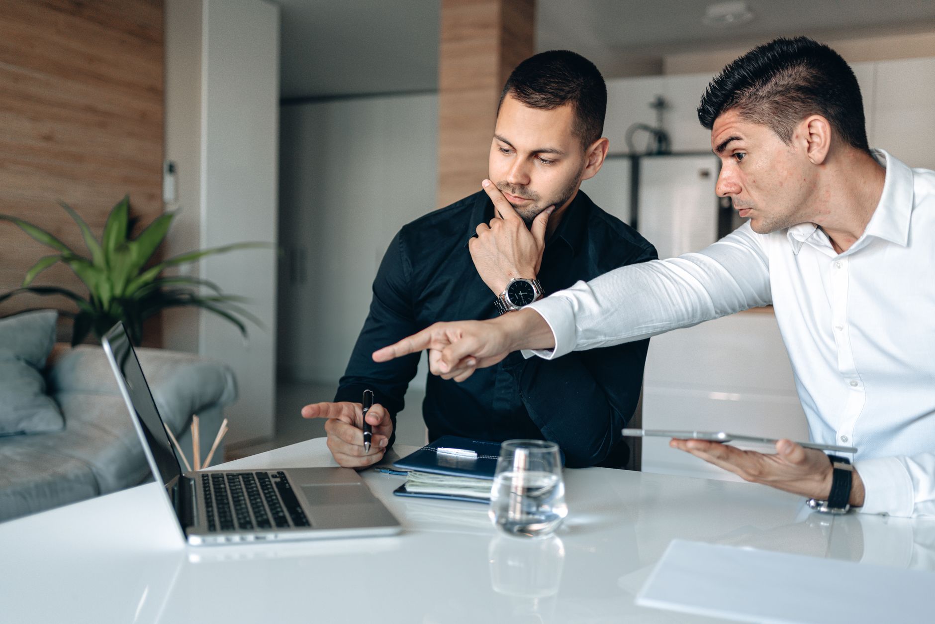 Two Men In An Office Intensely Focusing On A Lapto 2