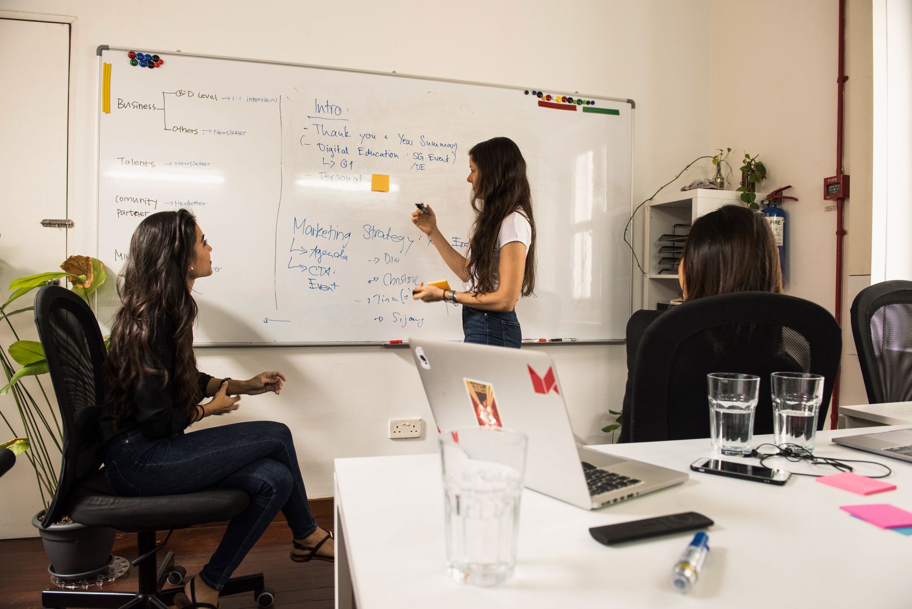 Business Women Discussing Strategy At A Whiteboard