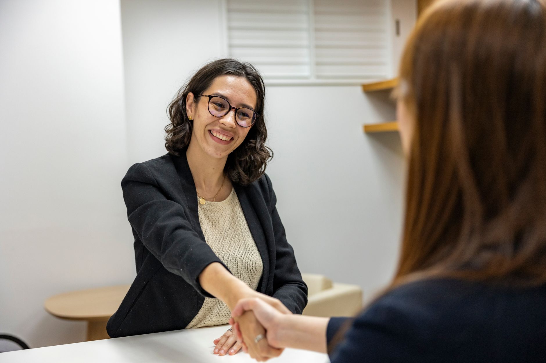 Businesswomen Shaking Hands In An Office Represen