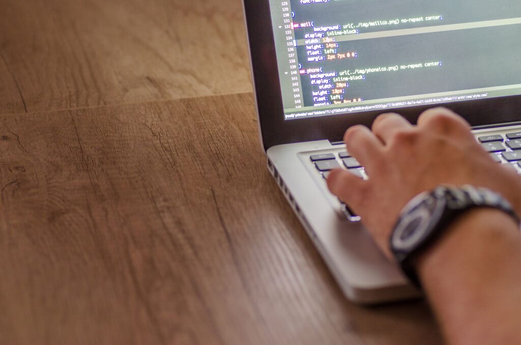 Dedicated Development Team: Expert It Staff Augmentation Solutions 2 Close-Up Of A Person Coding On A Laptop, Showcasing Web Development And Programming Concepts.