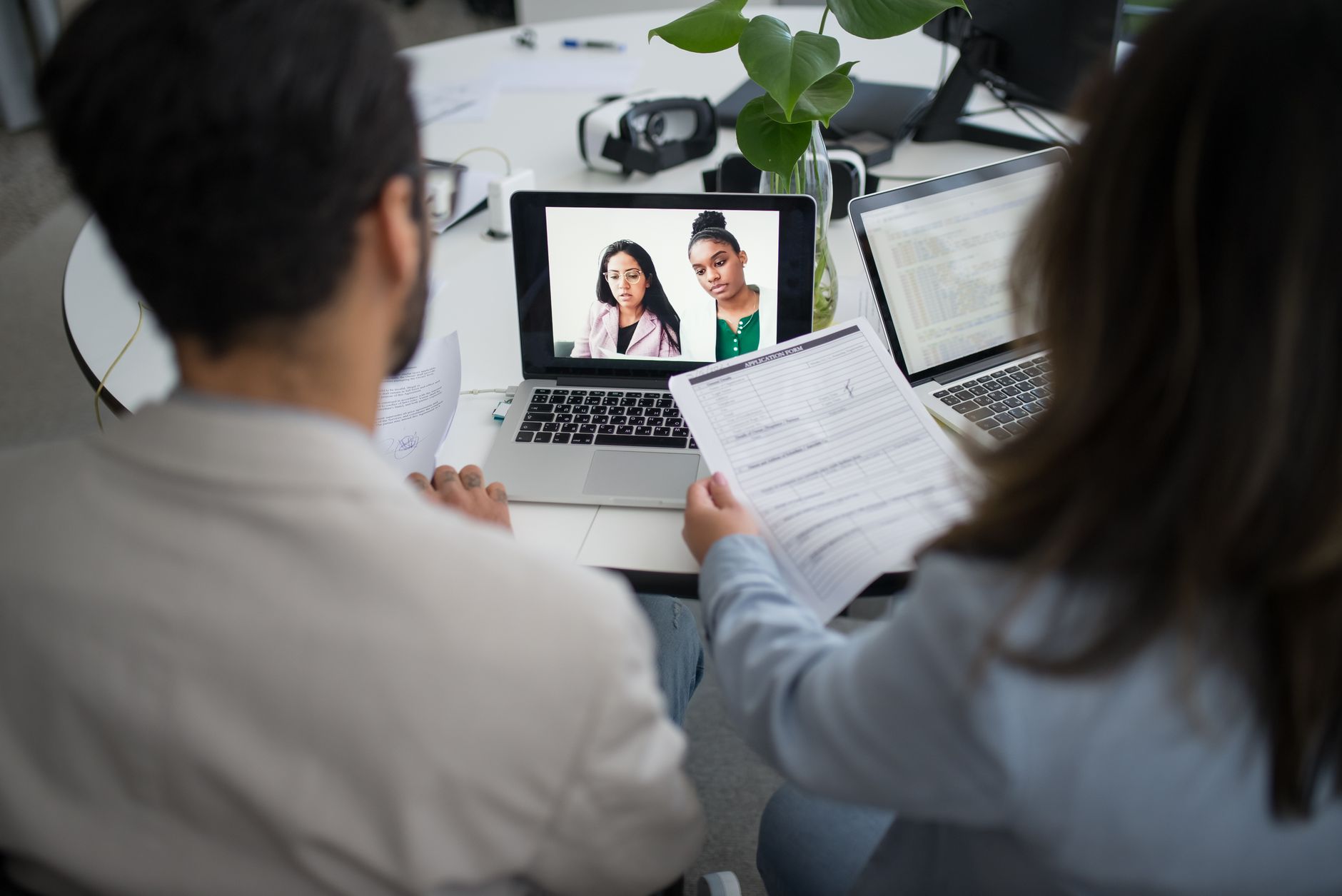 Two Professionals Conduct A Virtual Job Interview Using Laptops In A Modern Office.